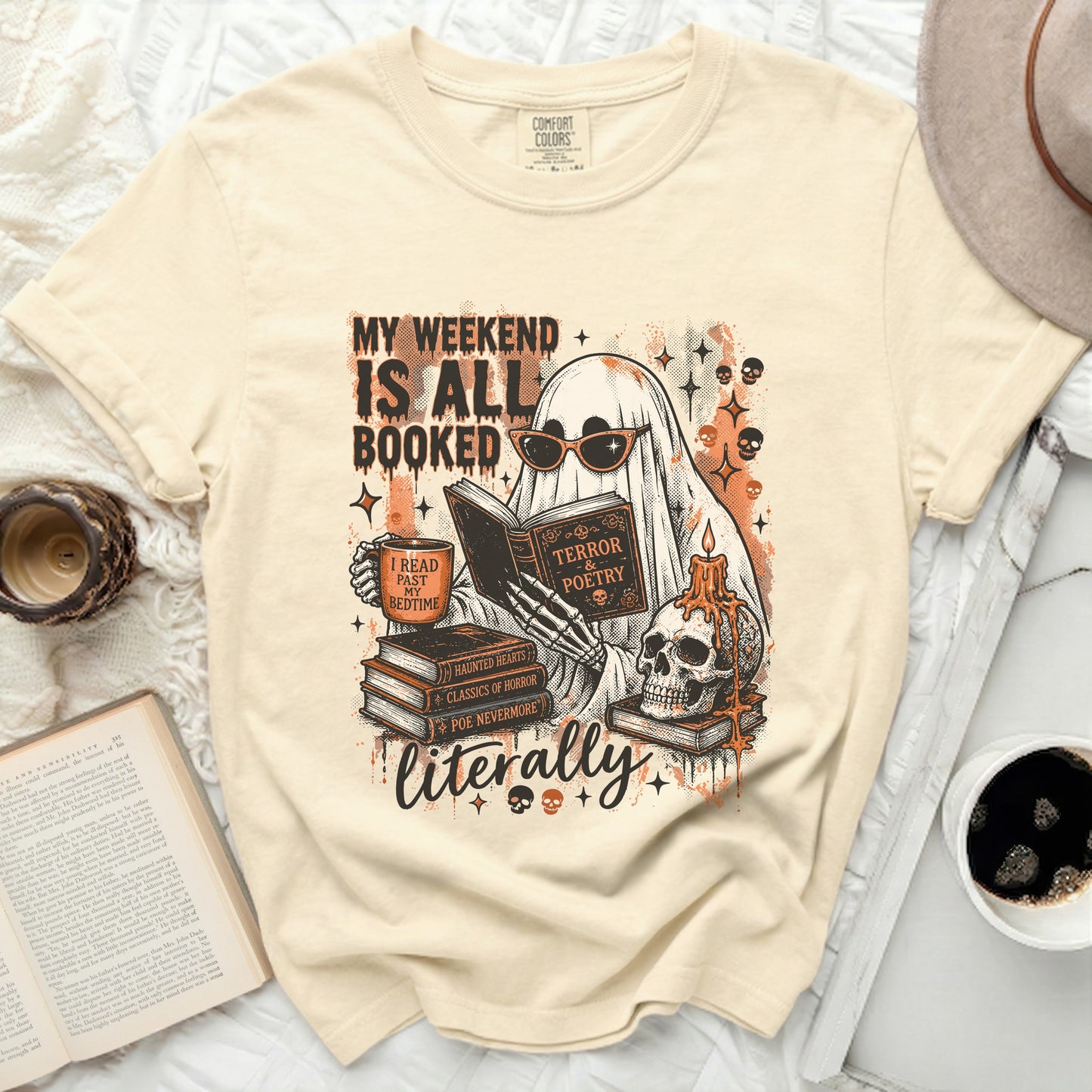 A cream shirt featuring a ghost reading books and wearing sunglasses.