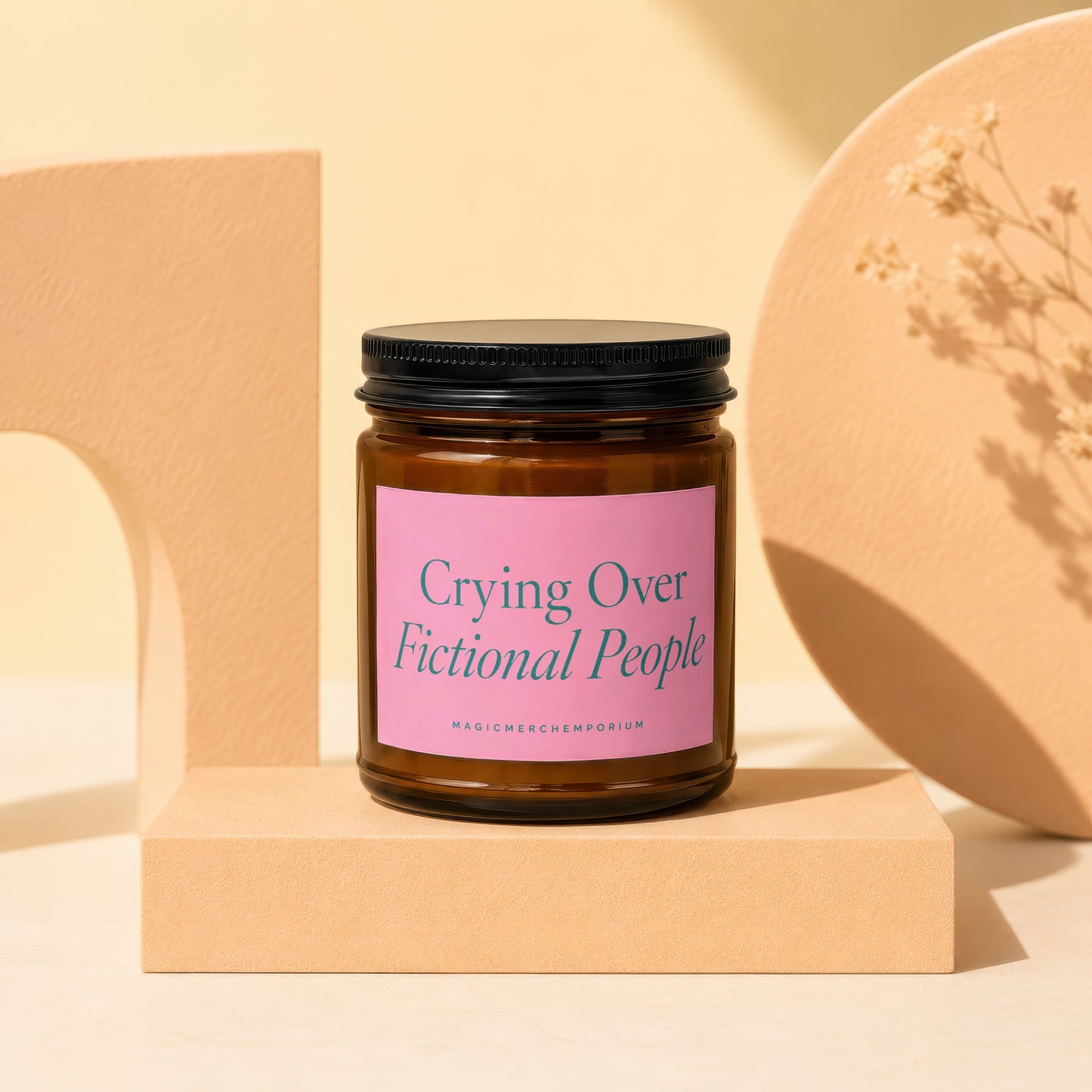 Amber jar candle with pink label reading "Crying Over Fictional People".