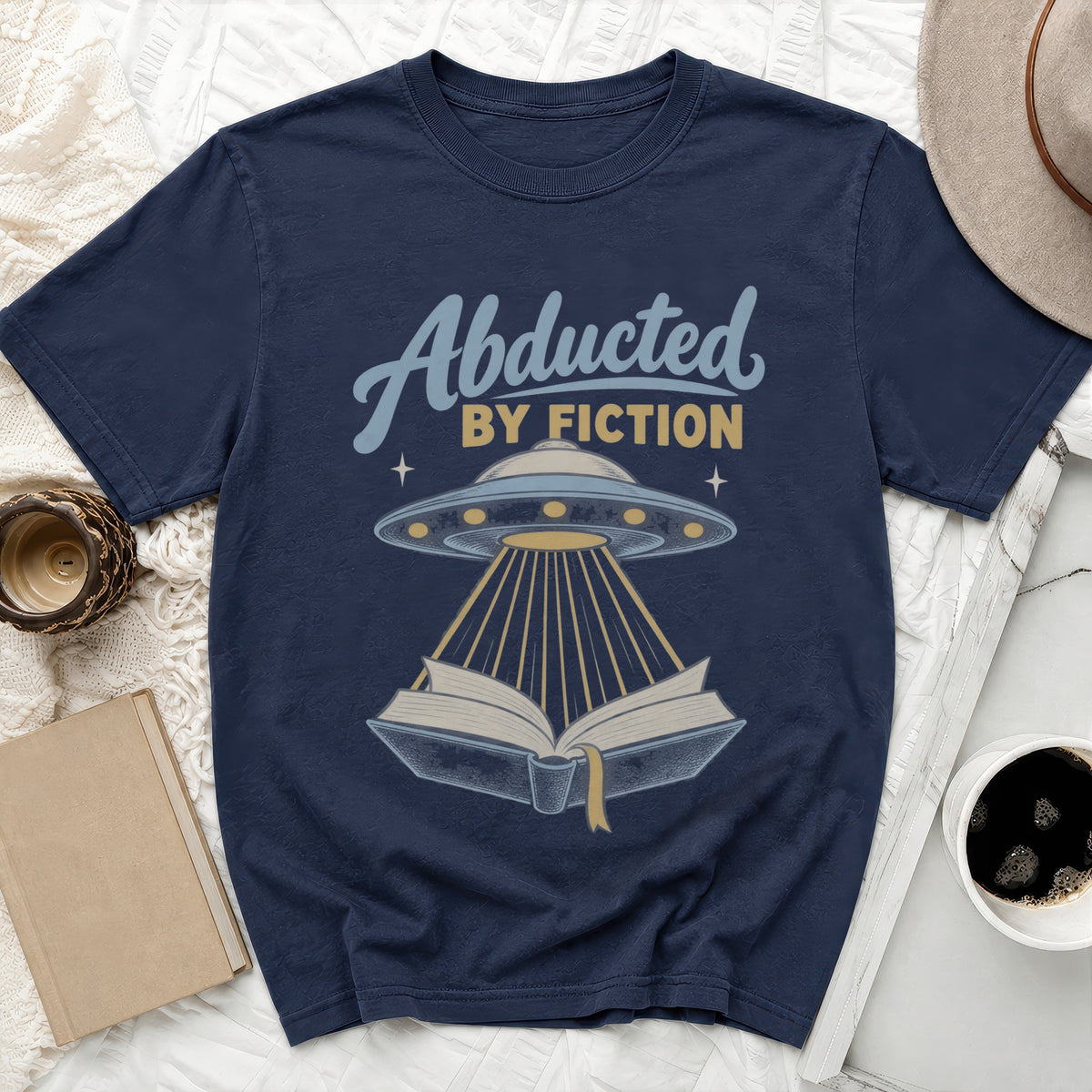 Navy t-shirt with "Abducted By Fiction" text and alien spaceship over an open book.