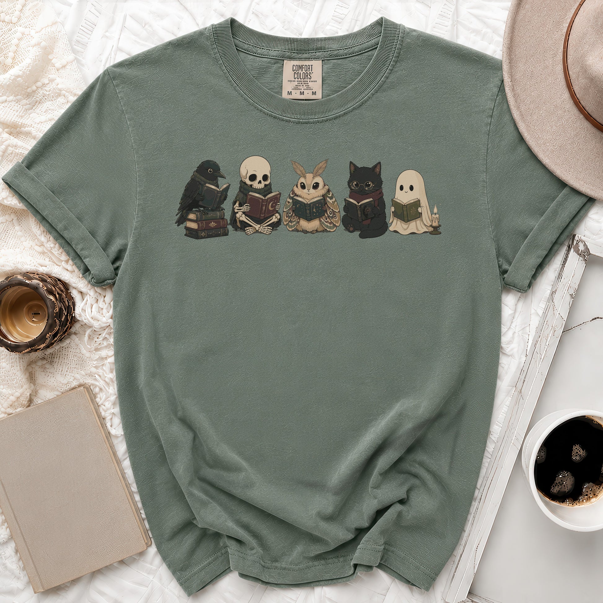 Green t-shirt featuring a crow, skeleton, moth, cat, and ghost reading books.