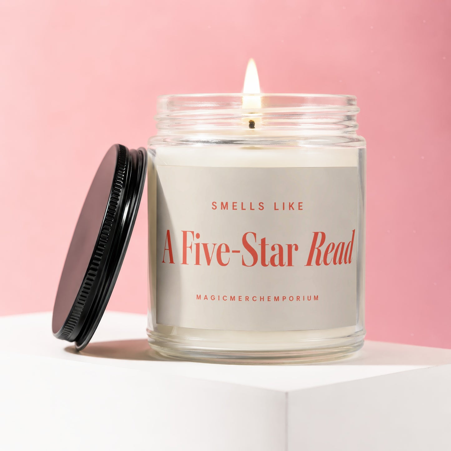 Lit candle in glass jar with black lid, reads "Smells Like A Five-Star Read".