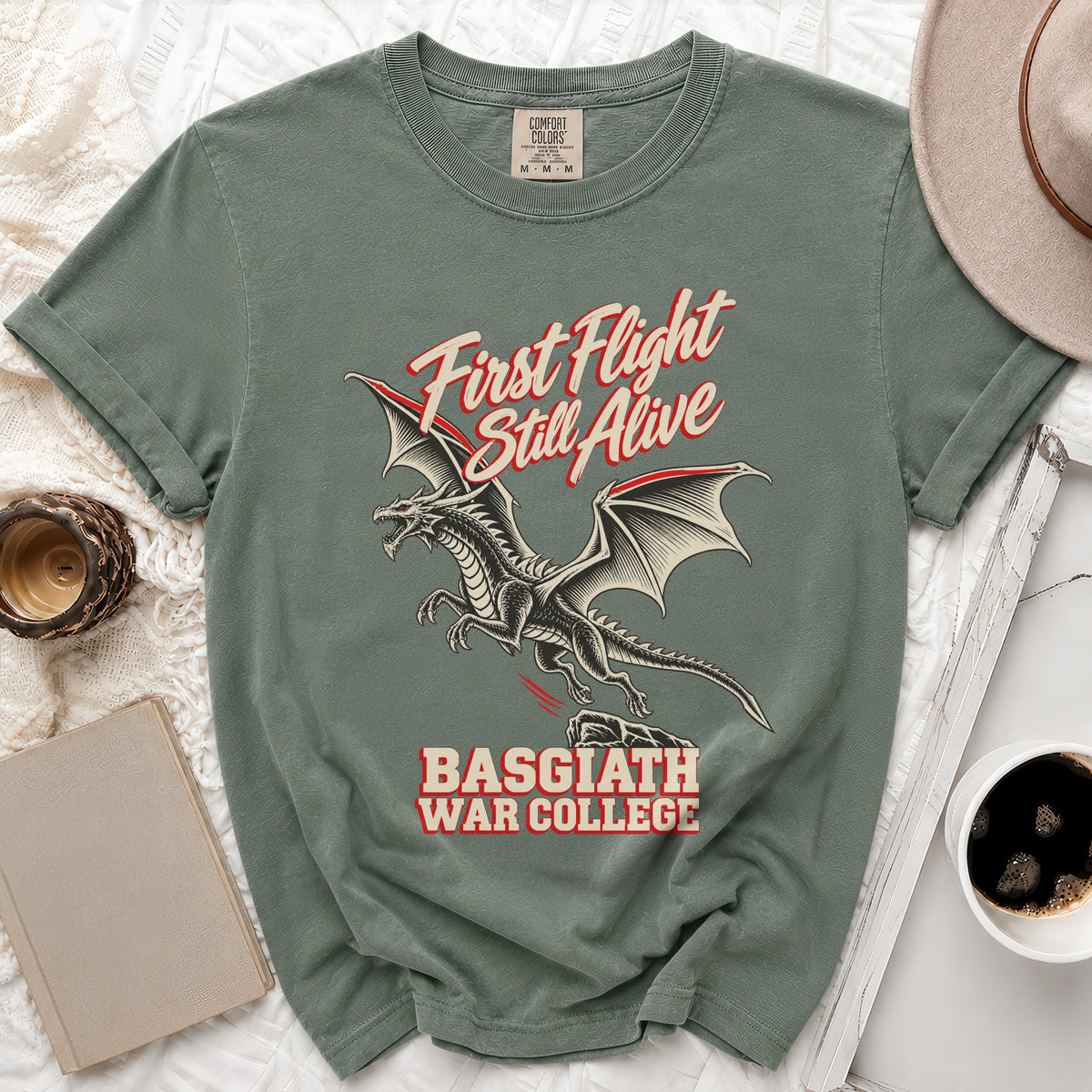 Green t-shirt with a dragon graphic and text "First Flight Still Alive BASGIATH WAR COLLEGE".