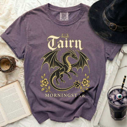 Purple t-shirt with a black dragon, gold text "Tairn Morningstar," and book graphic.