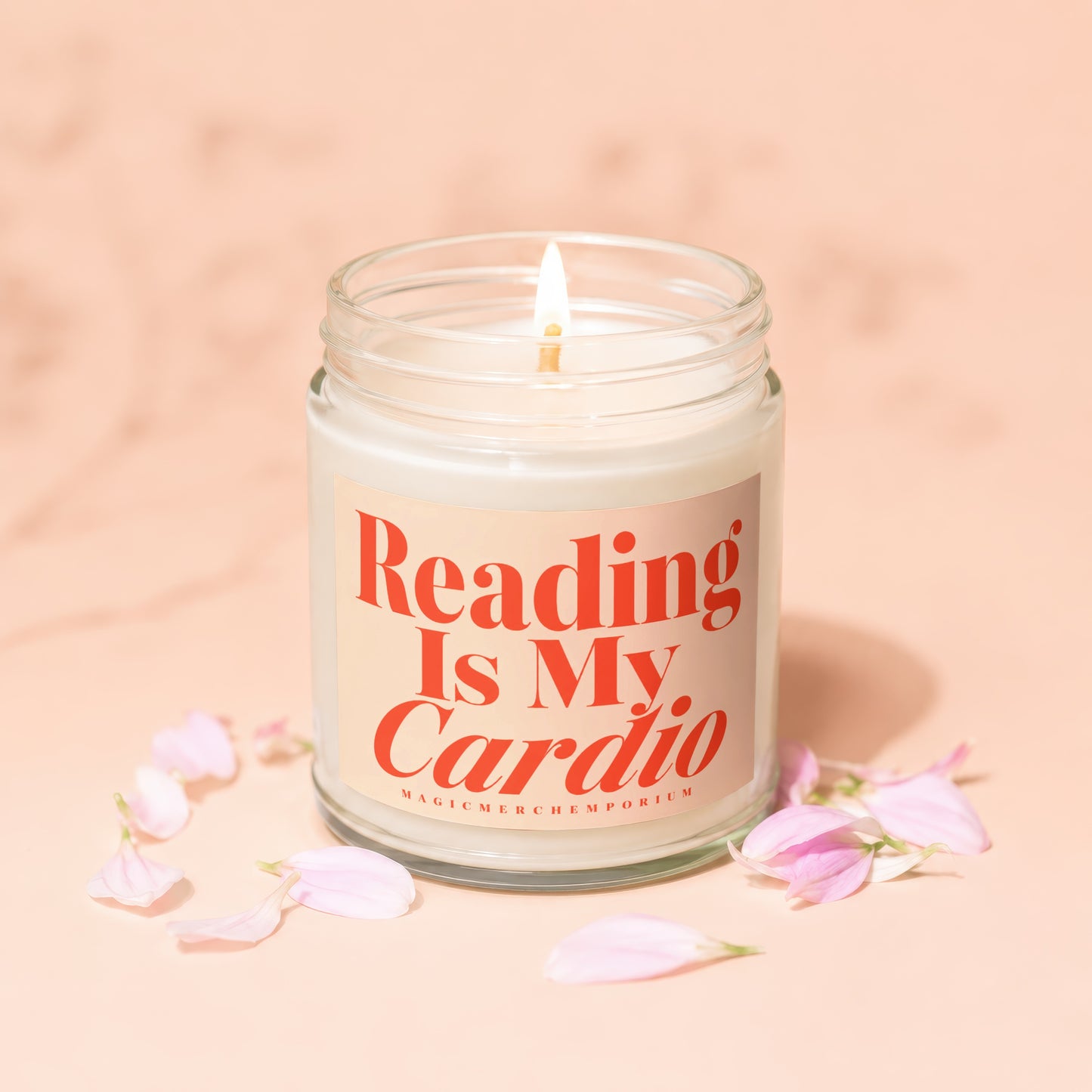 Candle with "Reading Is My Cardio" text and pink flower petals.