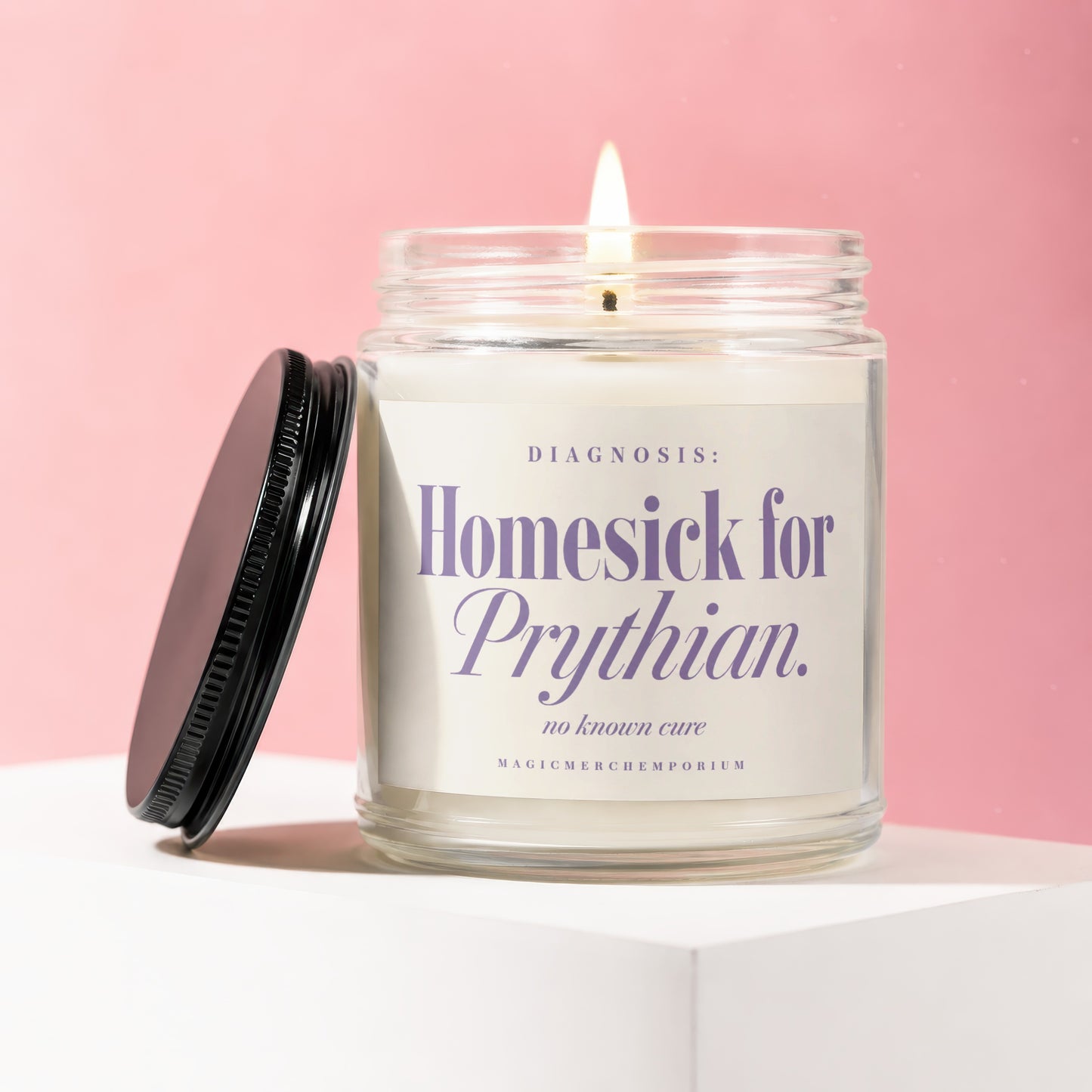 Glass candle with lit wick, labeled "DIAGNOSIS: Homesick for Prythian. no known cure".