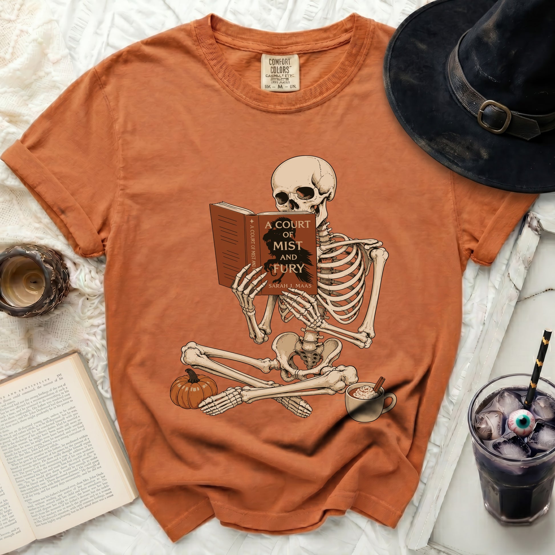 Skeleton reading "A Court of Mist and Fury" book, Halloween-themed.
