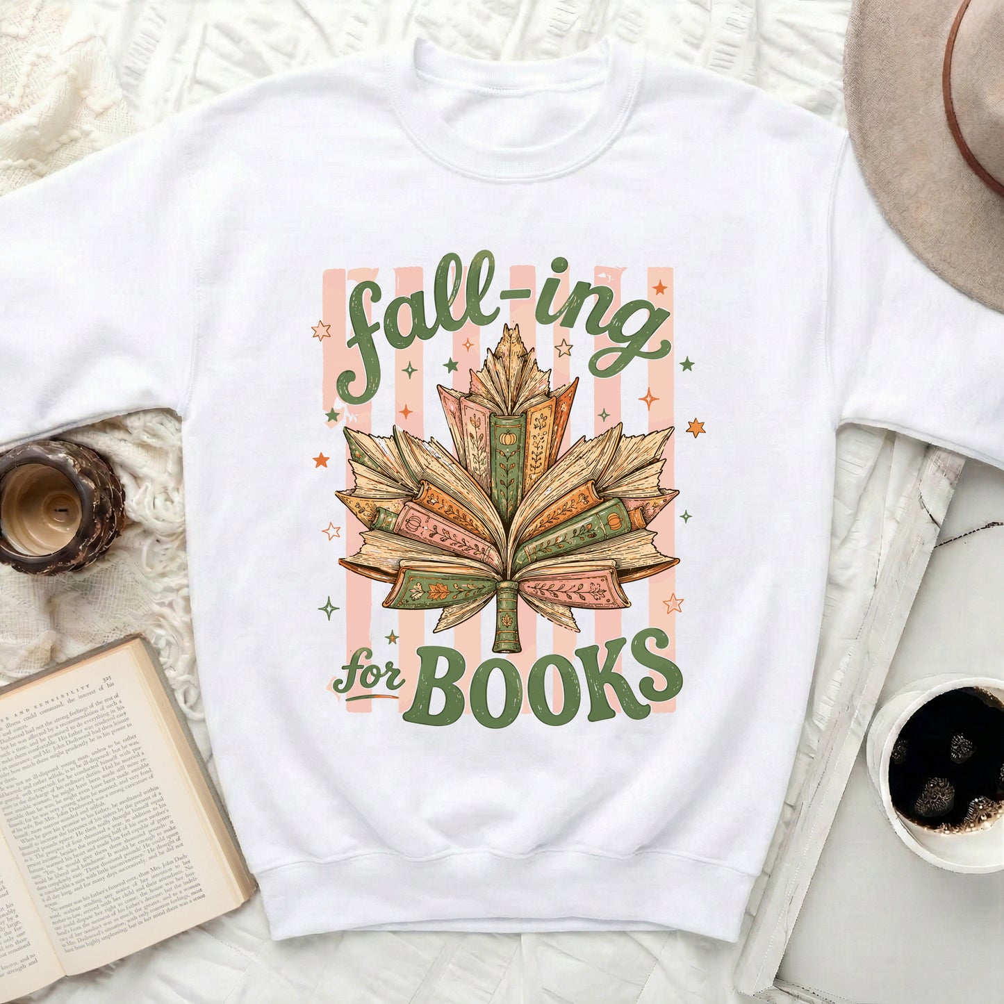White sweatshirt with "fall-ing for BOOKS" text and leaf made of books.