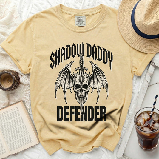 Yellow t-shirt with a skull, wings, sword, and text "SHADOW DADDY DEFENDER".