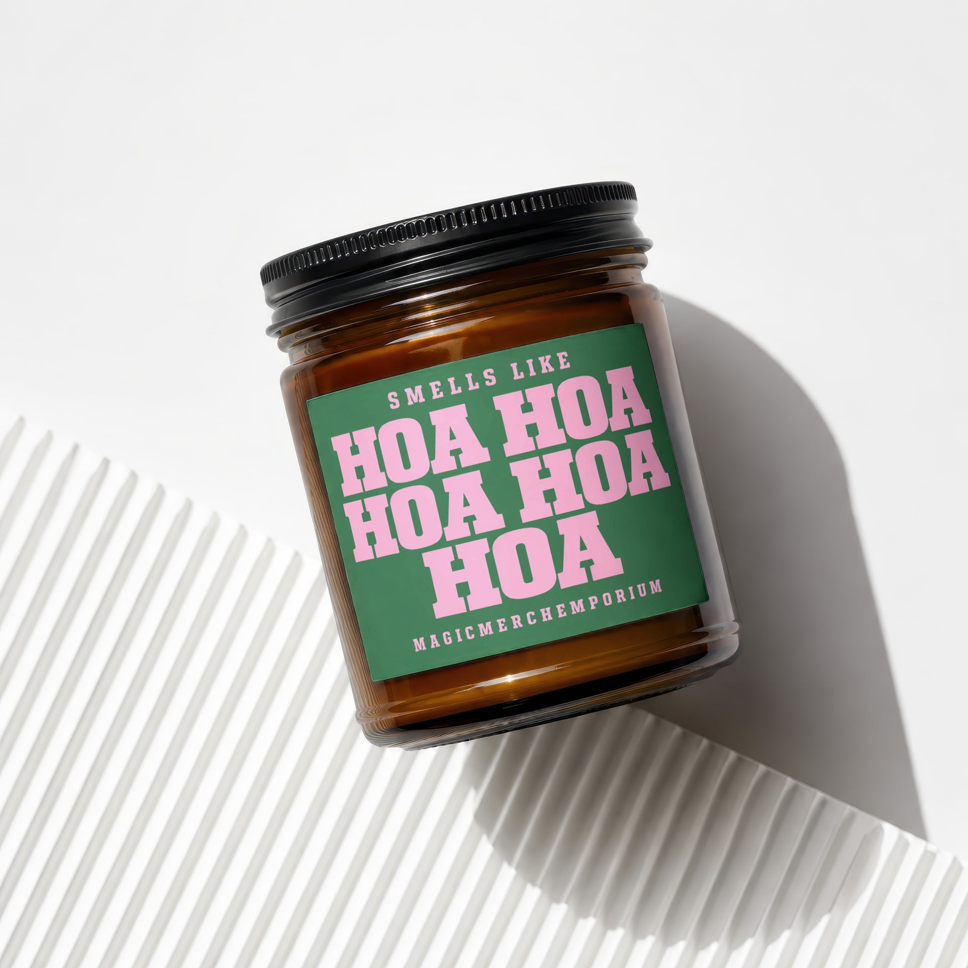 Candle with green label that says "Smells Like Hoa Hoa Hoa Hoa Magicmerchemporium"