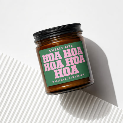 Candle with green label that says "Smells Like Hoa Hoa Hoa Hoa Magicmerchemporium"