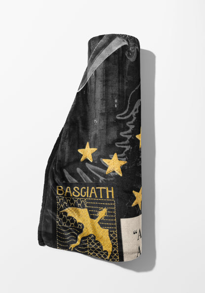 Rolled black blanket with gold stars, dragon, and "BASGIATH" text.