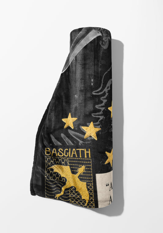 Rolled black blanket with gold stars, dragon, and "BASGIATH" text.