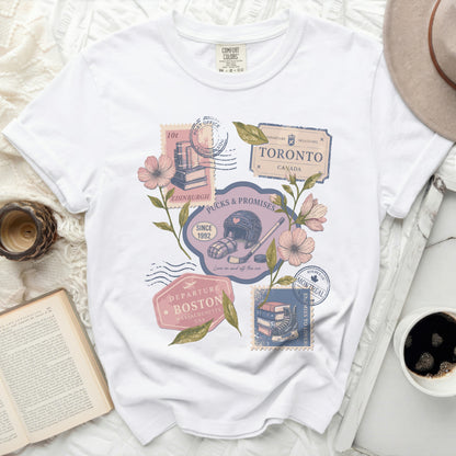 White t-shirt with vintage travel stamps and hockey imagery.