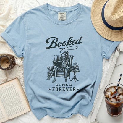 Light blue t-shirt with "Booked Since Forever" text and skeleton reading.