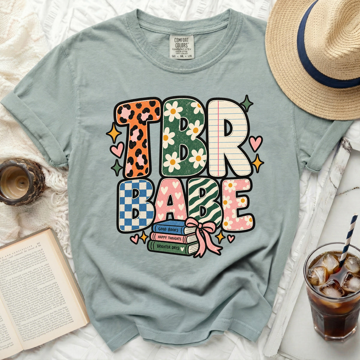 TBR Babe graphic tee with stacked books and floral accents.