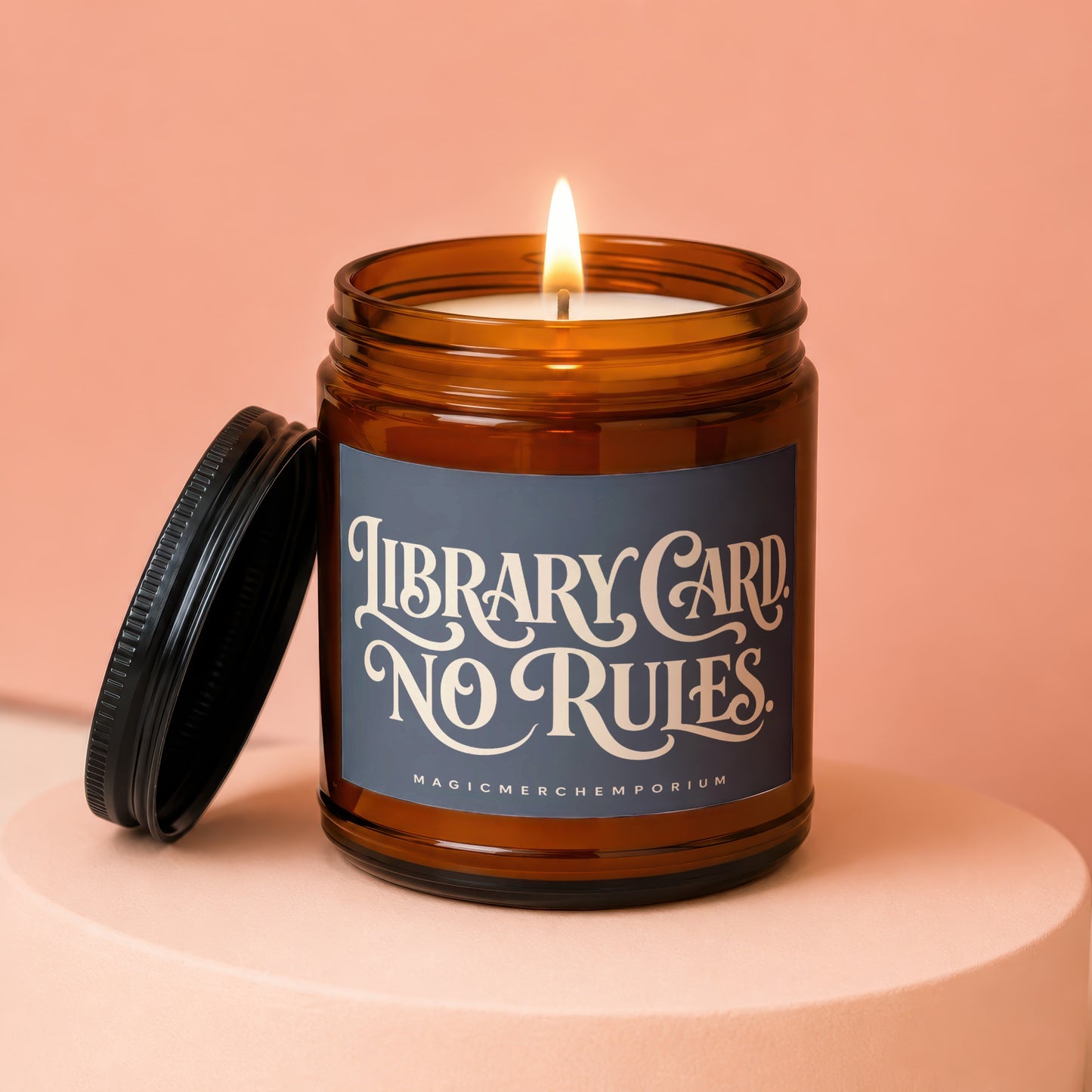 Lit amber jar candle with black lid, featuring text "LIBRARY CARD NO RULES".