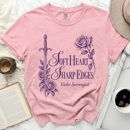 Pink t-shirt with purple graphic of sword, roses, and text "Soft Heart Sharp Edges Violet Sorrengail".