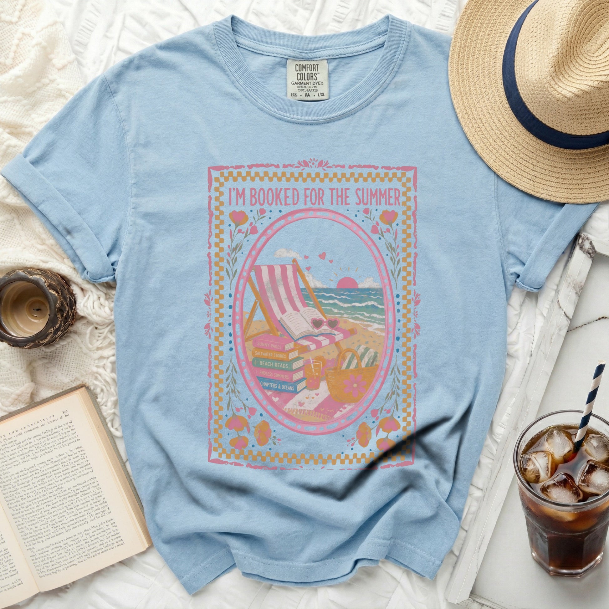 Light blue t-shirt with "I'm Booked for the Summer" graphic of beach items and books.