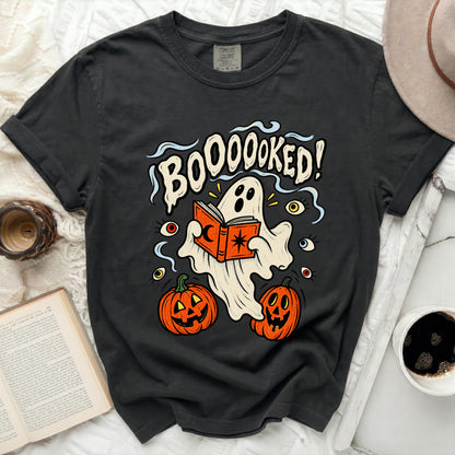 Dark t-shirt with ghost reading book and text "BOOOOOKED!".