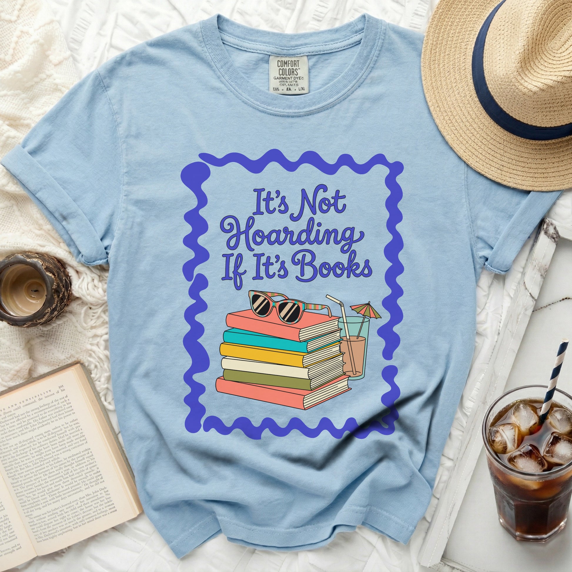 Light blue t-shirt with "It's Not Hoarding If It's Books" and stacked books graphic.