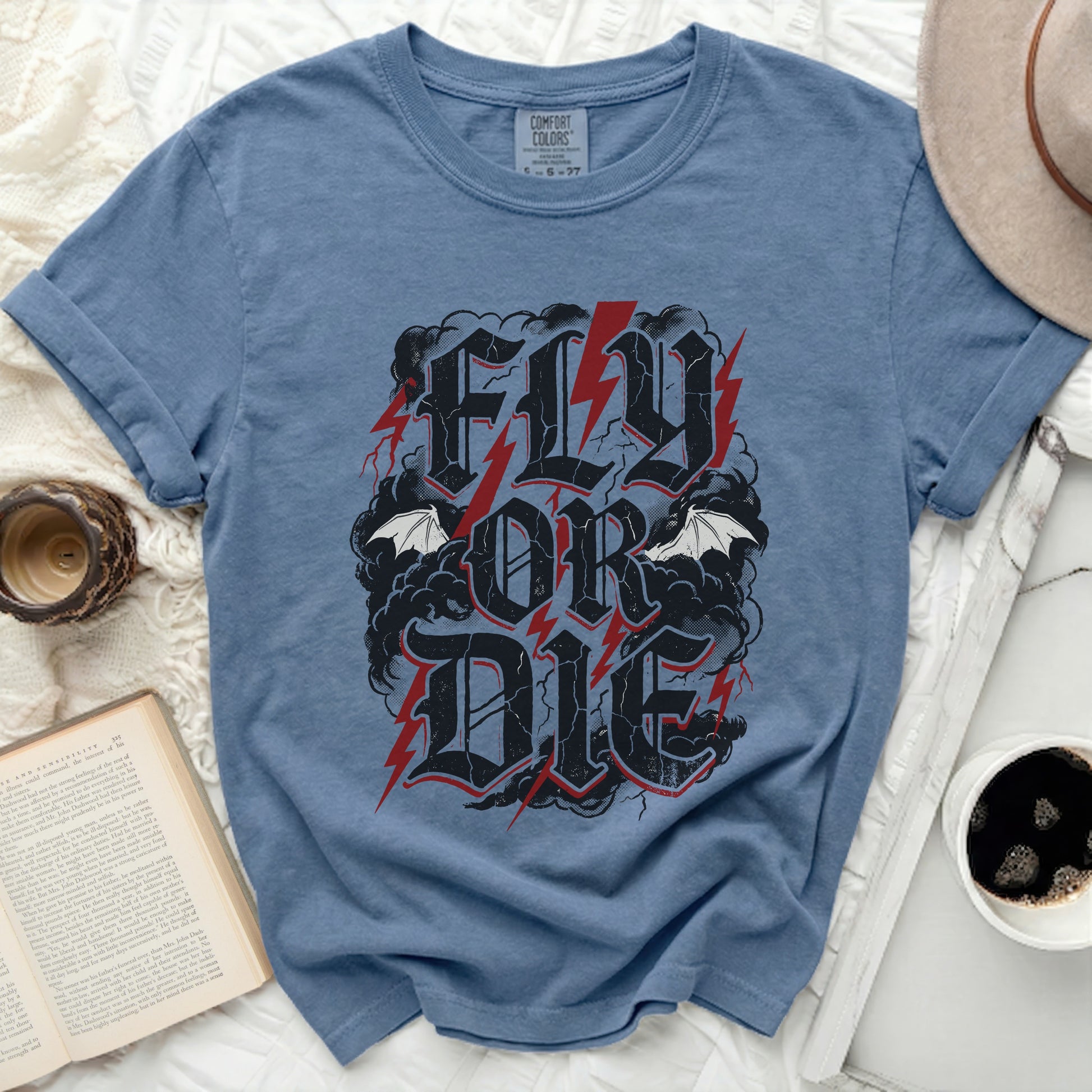Blue t-shirt with "FLY OR DIE" text, lightning, and bats graphic.