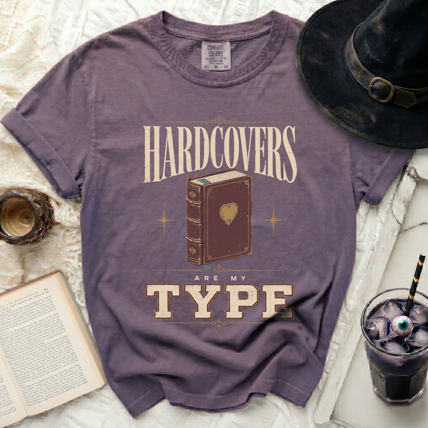 Purple t-shirt with "Hardcovers Are My Type" graphic and an open book.