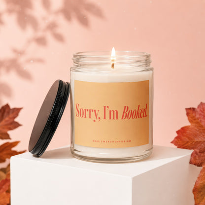 Lit candle in a jar with lid off, featuring "Sorry, I'm Booked." text.