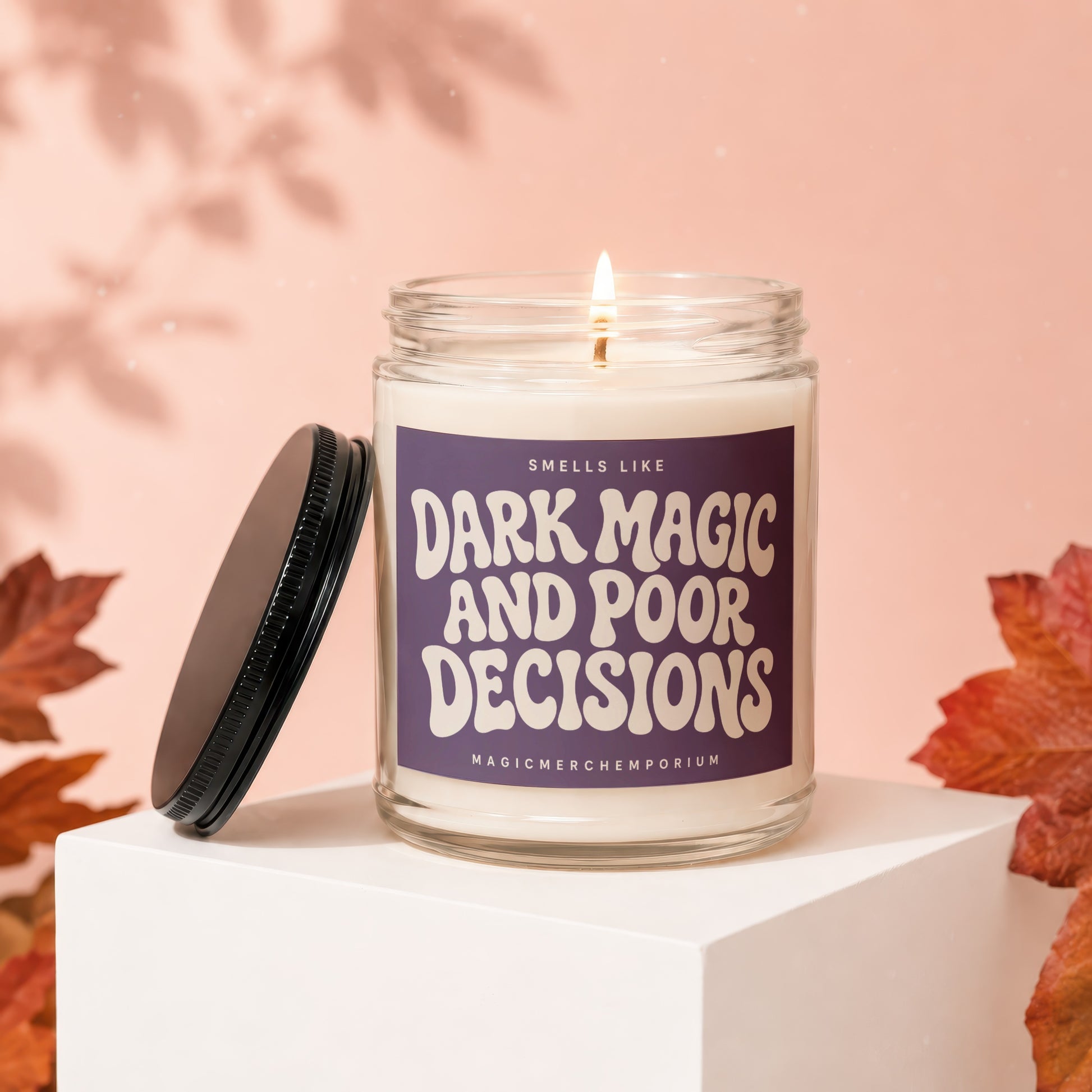Candle with "Smells Like Dark Magic And Poor Decisions" text on a purple label.