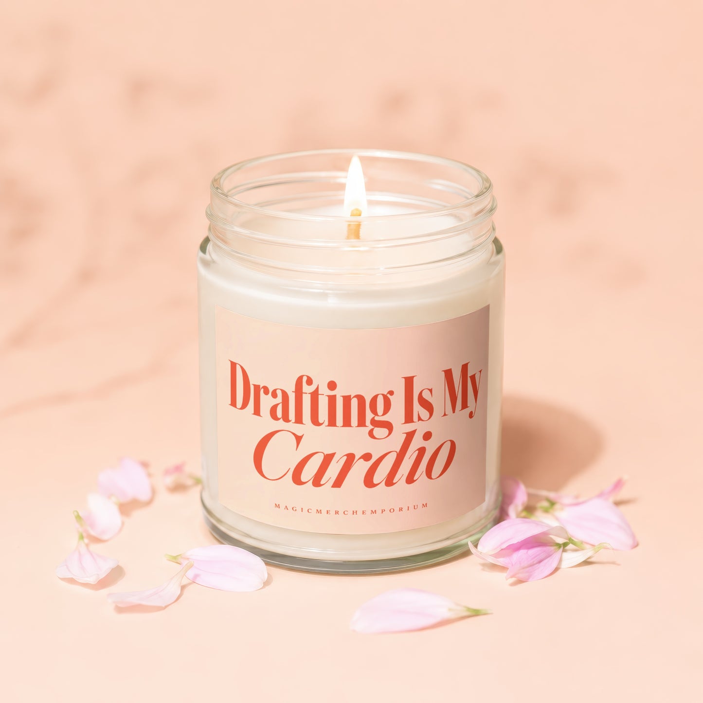 Lit candle in a glass jar with "Drafting Is My Cardio" text on label.
