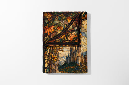 Faux stained glass blanket features a castle on a hill with floral borders.