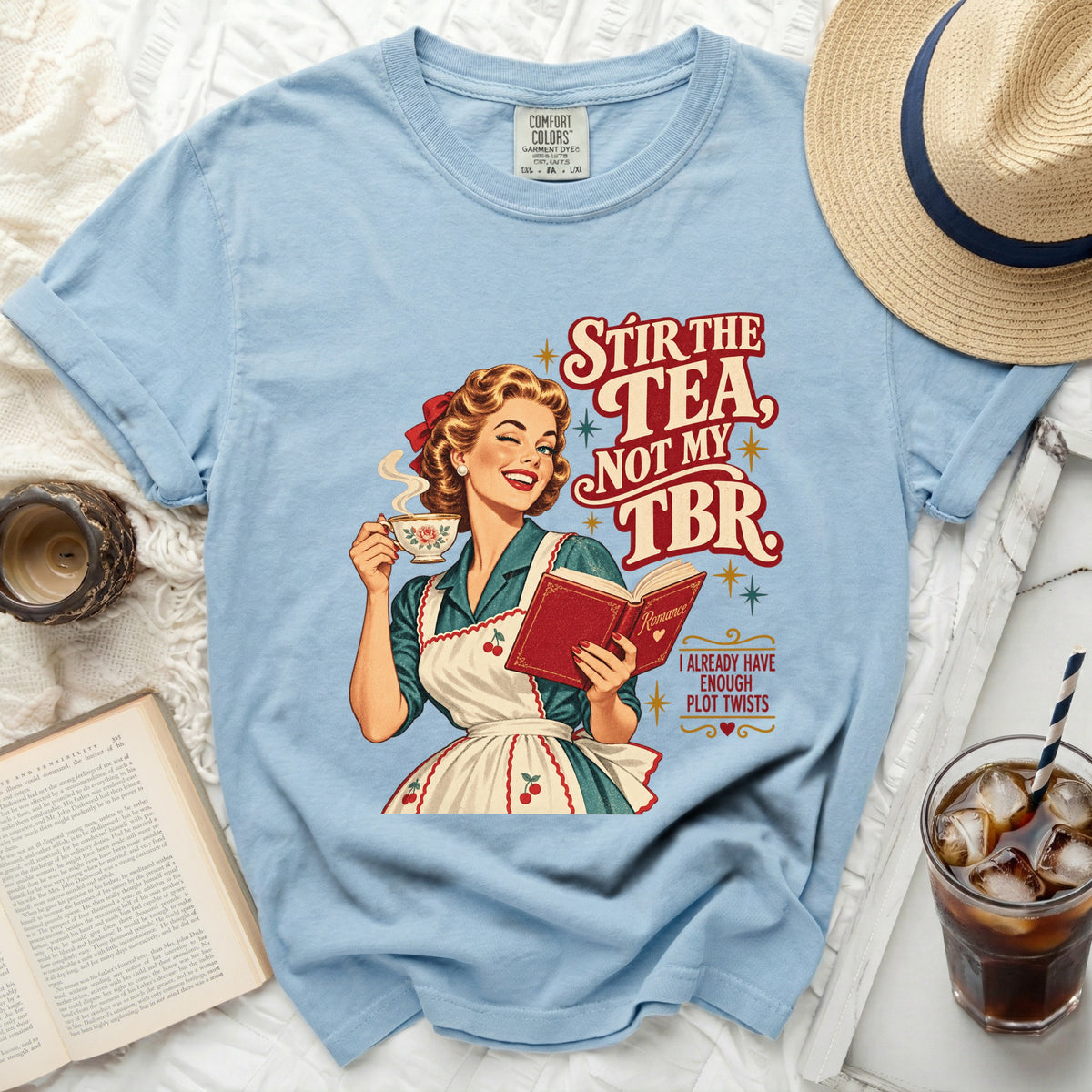 Light blue t-shirt with retro woman holding tea and book, text "Stir the Tea, Not My TBR."