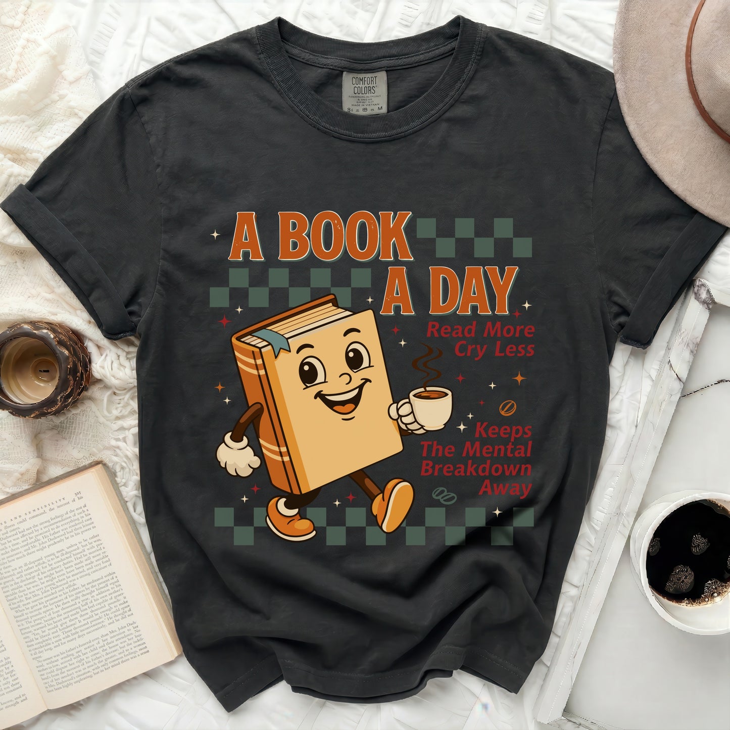 A cartoon book holding coffee says "A Book a Day" and "Read More Cry Less".