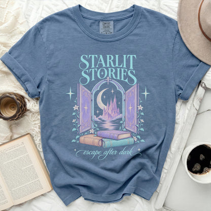 Blue t-shirt with "Starlit Stories escape after dark" text and castle graphic.
