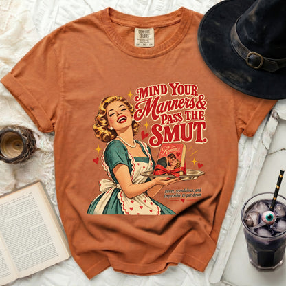 Orange t-shirt with graphic of a laughing woman holding a romance novel.