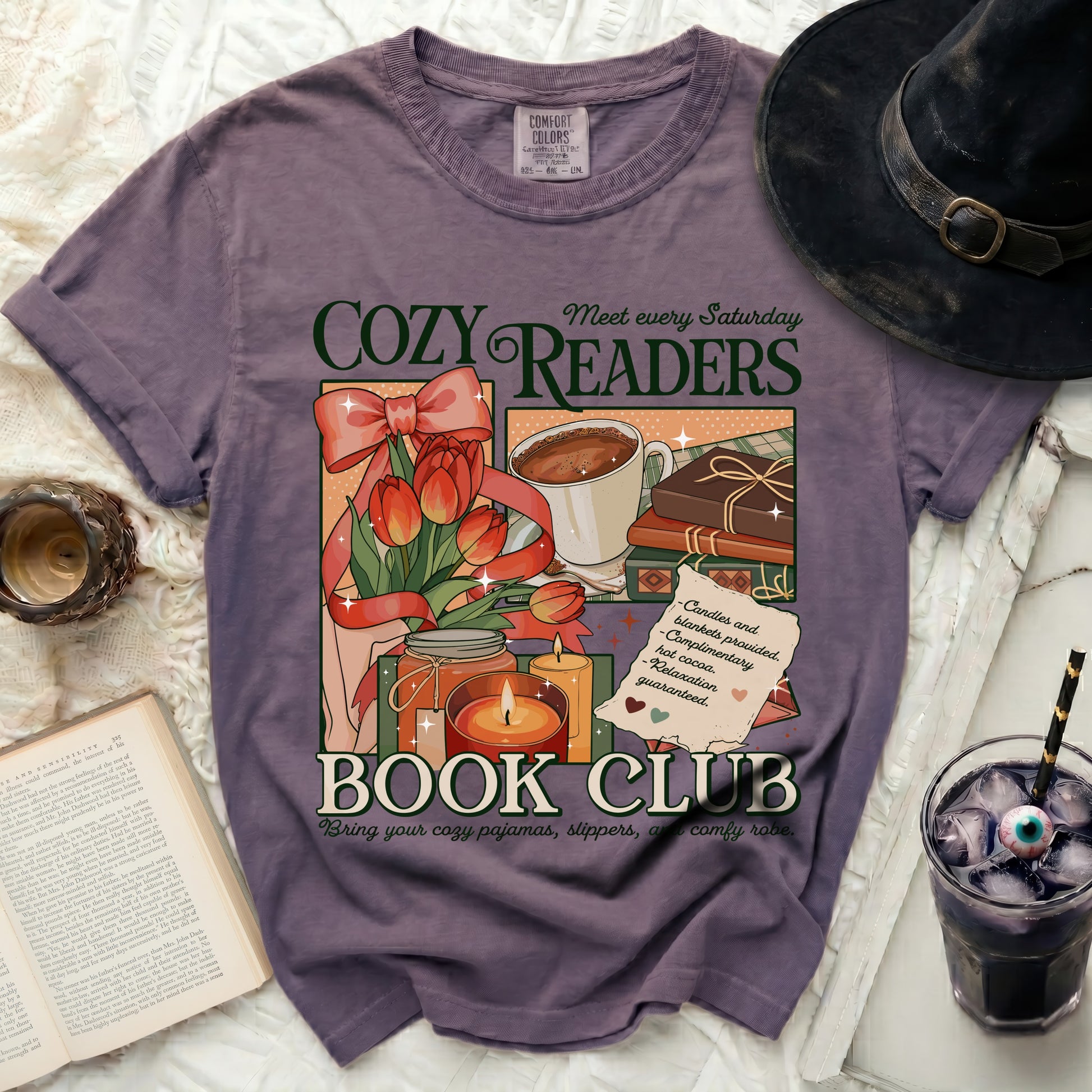 Purple t-shirt with "Cozy Readers Book Club" graphic including tulips, cocoa, and candles.