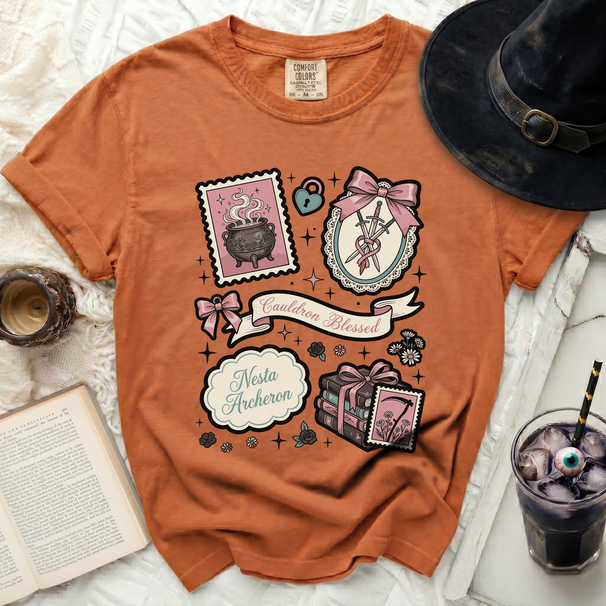 Orange t-shirt with "Cauldron Blessed" and "Nesta Archeron" graphic.