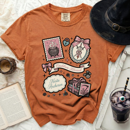 Orange t-shirt with "Cauldron Blessed" and "Nesta Archeron" graphic.