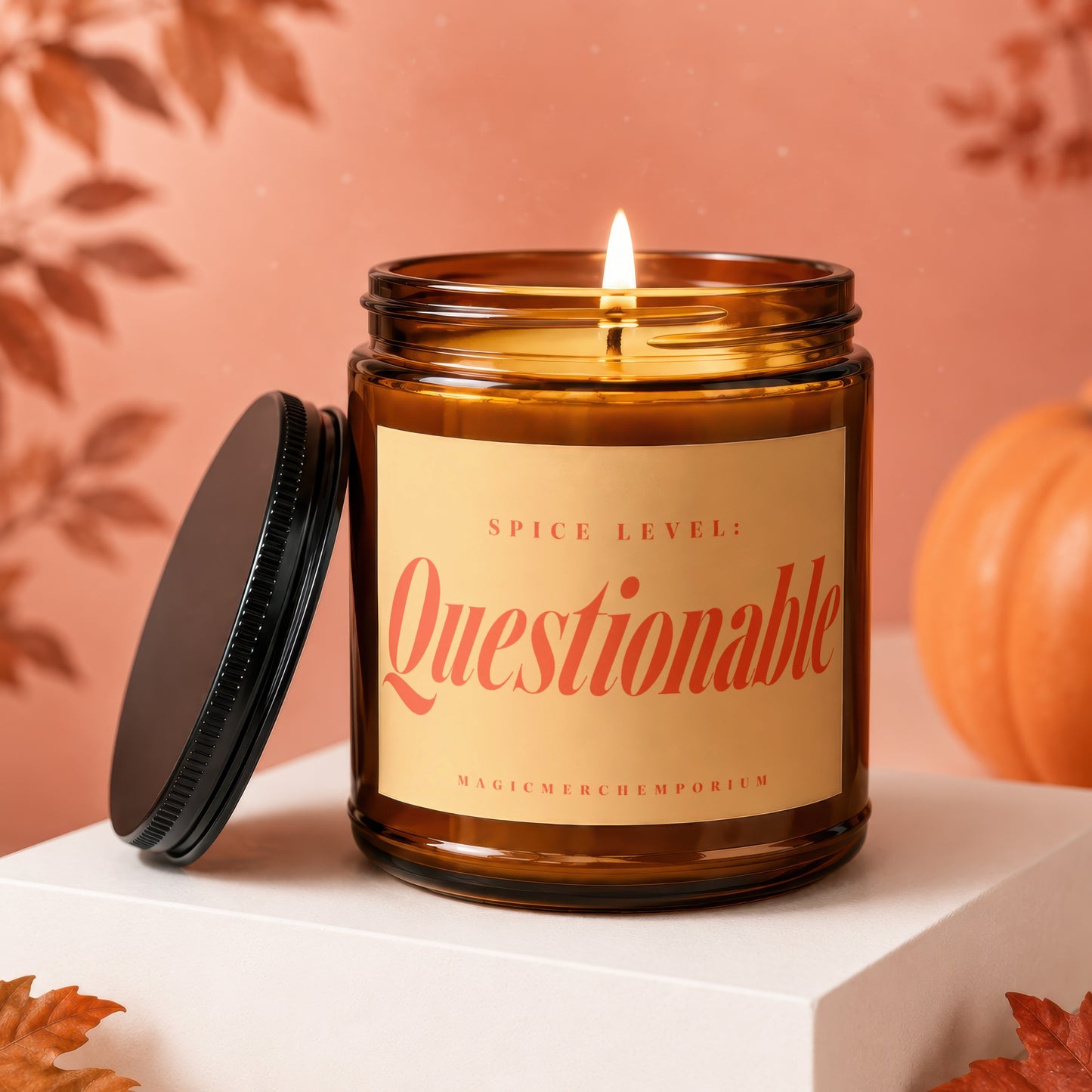 Amber candle with "Spice Level: Questionable" label on display pedestal near a pumpkin.