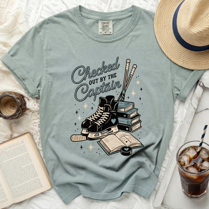 T-shirt with ice skates, books, and "Checked Out By The Captain" text.