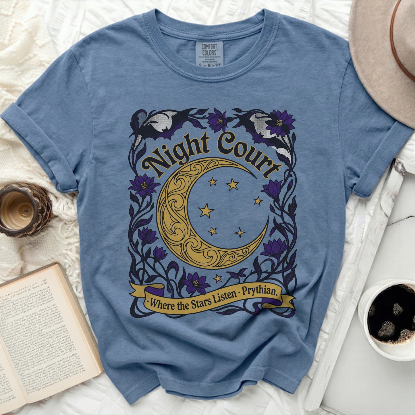 Blue t-shirt with gold, purple, and black "Night Court Where the Stars Listen · Prythian" graphic.