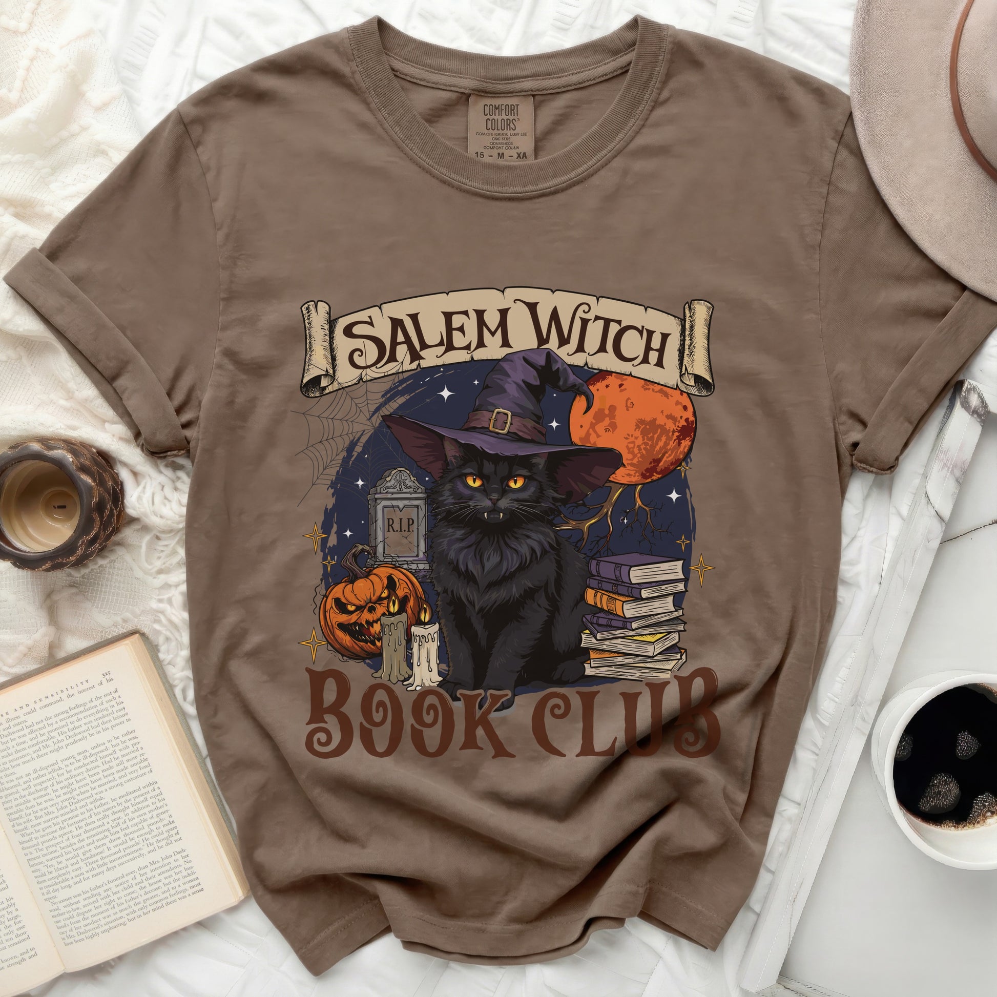 Brown t-shirt with a black cat, witch hat, pumpkin, and "Salem Witch Book Club" text.