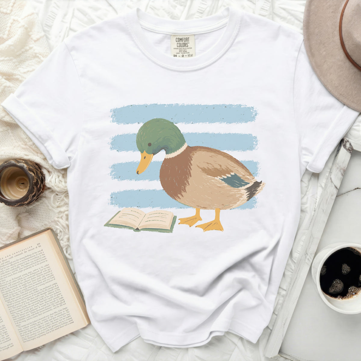 White t-shirt with illustration of a duck reading a book.