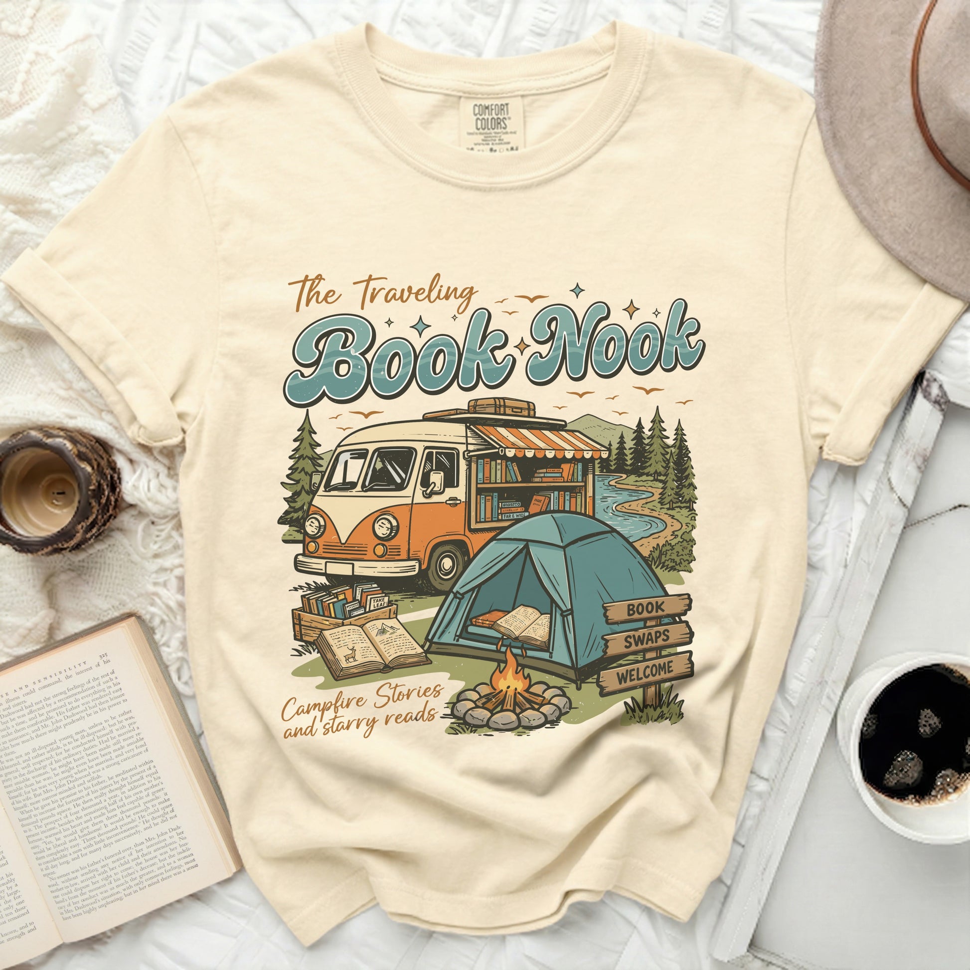 The Traveling Book Nook graphic on a cream t-shirt with a van, tent, and books.