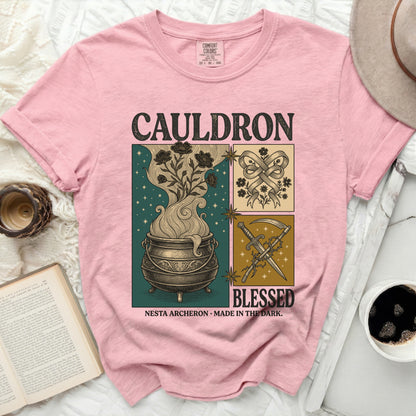 Pink t-shirt with "Cauldron" and "Blessed" text, featuring witchy graphics.