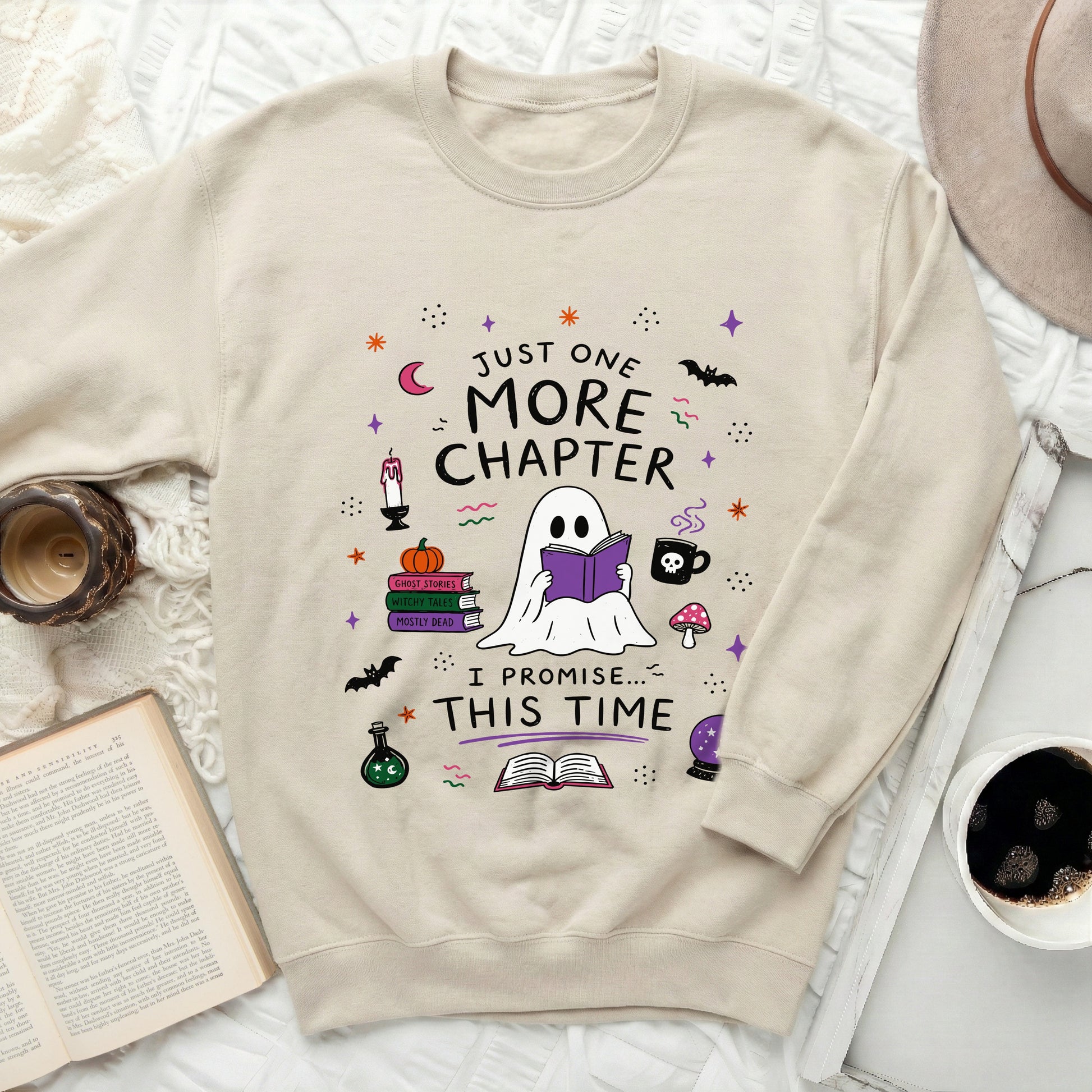 Cream sweatshirt with "Just One More Chapter I Promise This Time" text and Halloween icons.