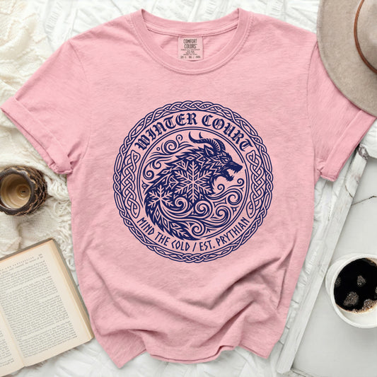 Pink t-shirt with navy blue circular wolf and snowflake graphic.