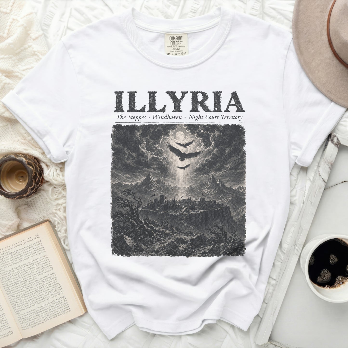White t-shirt with "ILLYRIA" text and a dark, detailed landscape illustration.