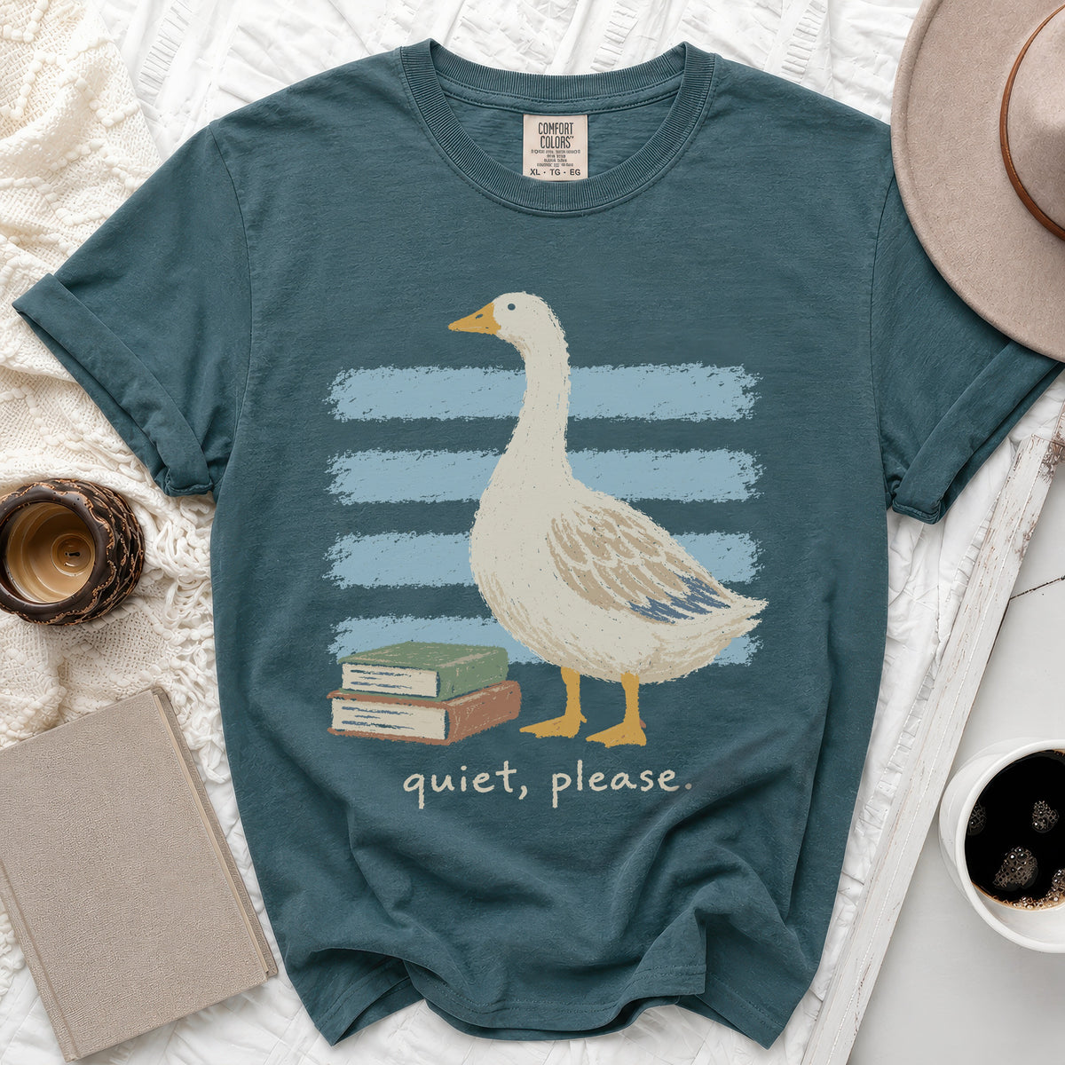 Teal t-shirt with a goose standing by books, text reads "quiet, please."