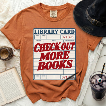 Orange t-shirt with "Library Card Check Out More Books" graphic.