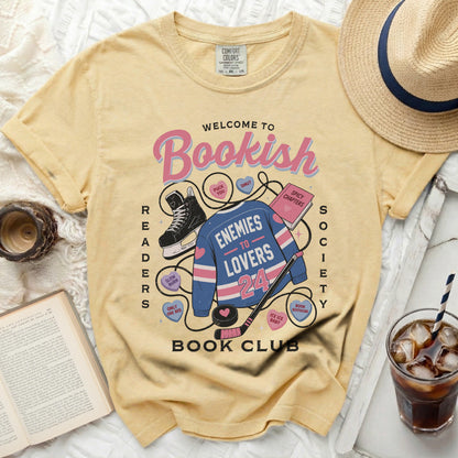 Yellow t-shirt with "Bookish Enemies to Lovers Book Club" graphic.